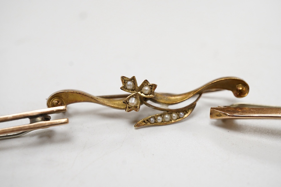 An Edwardian 15ct gold and seed pearl set foliate bar brooch, 41mm, together with a 9ct gold and gem set bar brooch and one other yellow metal and gem set bar brooch.